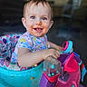 baby, child, messy_face, smiling, walker, toy, indoor, playful, happy, young_child, colorful, clothing, seat, person, portrait, cute, fun, early_childhood, infant, expression