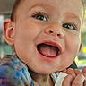 Ellamae joined the competition — help win amazing prizes! toddler, child, smiling, face, closeup, happy, expression, hand, bottle_cap, colorful_clothing, tie_dye, skin, eye, mouth, tongue, ear, person, portrait, indoor, cute