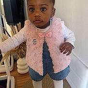 Kaëlyne a rejoint le concours — aidez-le/la à gagner de superbes lots ! toddler, child, girl, indoor, standing, pink_bows, pink_vest, denim_shorts, pink_shoes, curly_hair, big_eyes, floor_mat, wooden_floor, home_decor, vase, dried_plants, long_sleeve_shirt, cute, fashion, portrait