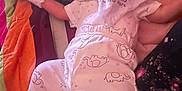 Levi is registered to the contest to win money with this photo: baby, infant, clothing, hat, blanket, quilt, elephant_pattern, lying_down, smile, face, white_clothing, socks, pajamas, bed, comfort, cute, newborn, soft_toys, warm, rest