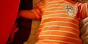 Levi joined the competition — help win amazing prizes! arms, baby, bed, blanket, child, comfort, cute, expression, face, indoors, infant, legs, lying_down, orange_striped_clothing, pajamas, portrait, relax, sleepwear, soft_fabric, young_child