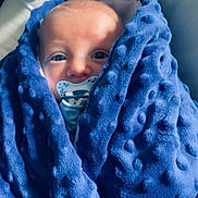 Eden participe au concours pour gagner de l'argent avec cette photo : baby, blanket, blue, pacifier, cushion, face, foot, sock, infant, soft_texture, cozy, resting, child, indoors, comfort, wrapped, cute, closeup, person, portrait