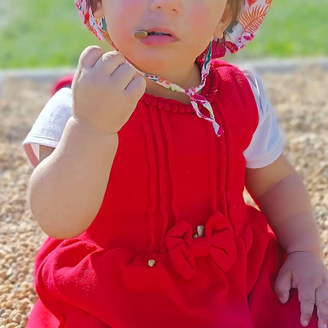 Louna participe au concours pour gagner de l'argent avec cette photo : baby_toddler_clothing, child, dress, eyewear, face, fashion_accessory, finger, gesture, grass, happy, jewellery, magenta, neck, people_in_nature, person, pink, red, skin, sleeve, toddler