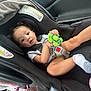 Rosaleigh joined the competition — help win amazing prizes! toddler, child, car_seat, toy, green_turtle, curly_hair, safety_harness, sock, car_interior, seatbelt, baby, infant, looking_at_camera, plastic_toy, window, automobile, seat, portrait, young_child, cute