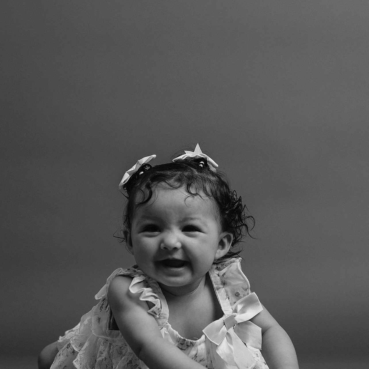 Rosaleigh is registered to the contest to win money with this photo: baby, black_and_white, bows, child, crawling, curly_hair, cute, dress, expression, face, front_view, hands, happy, infant, monochrome, playful, portrait, smiling, studio, young_child