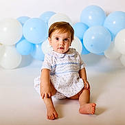Whitten joined the competition — help win amazing prizes! toddler, child, baby, blue_balloons, white_balloons, dress, sitting, curious, studio, portrait, innocent, cute, young_child, light_background, happy, small_feet, short_hair, indoor, smile, face