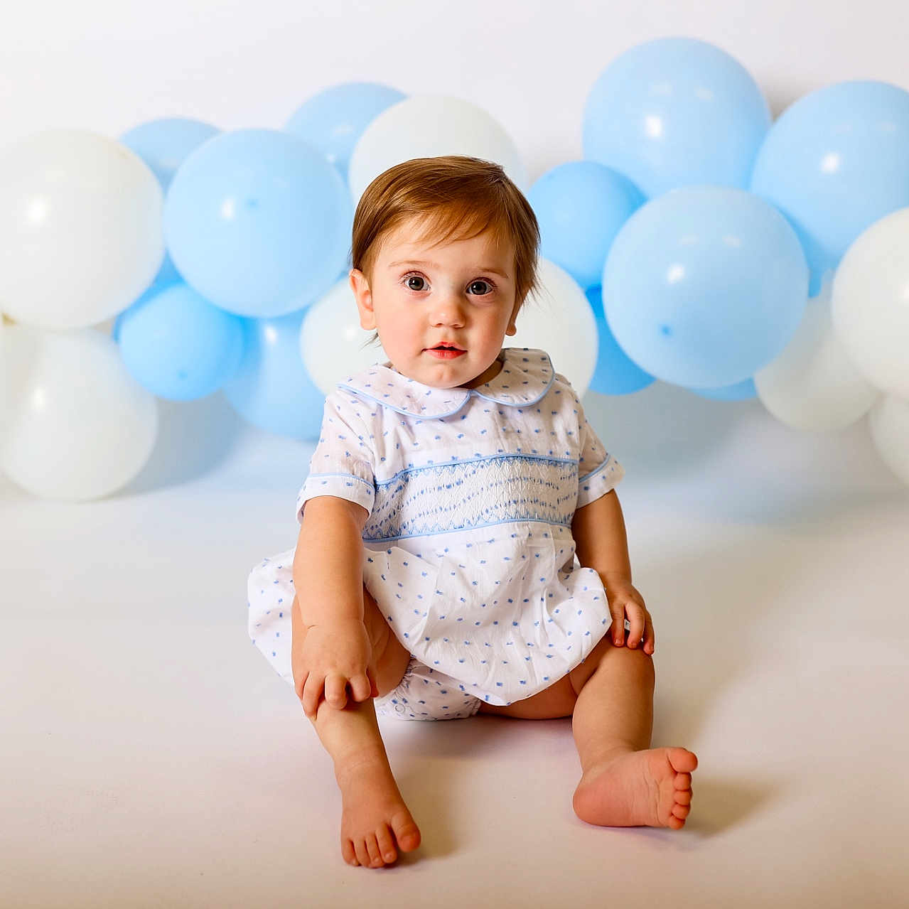 Whitten joined the competition — help win amazing prizes! baby, blue_balloons, child, curious, cute, dress, face, happy, indoor, innocent, light_background, portrait, short_hair, sitting, small_feet, smile, studio, toddler, white_balloons, young_child