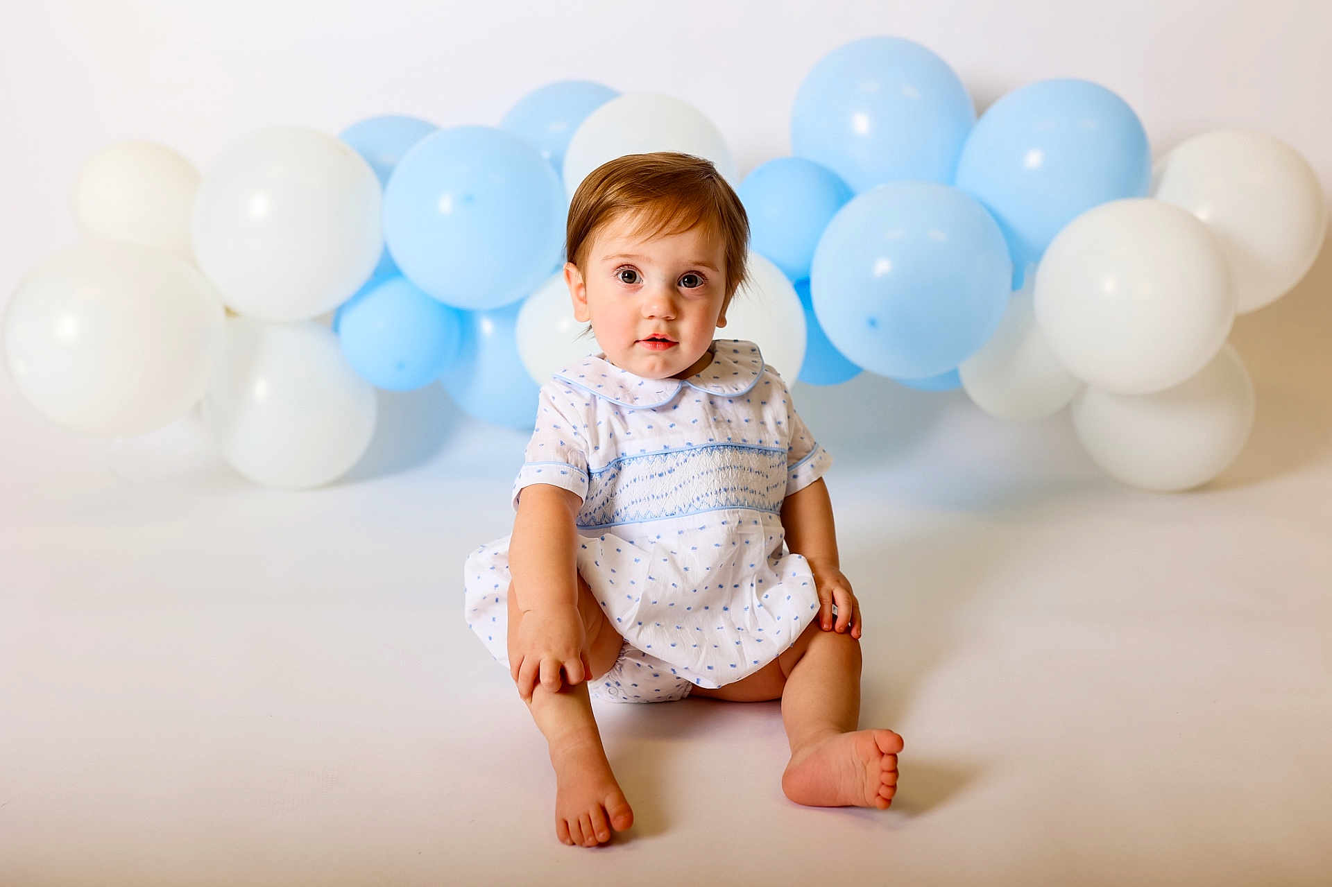 Whitten joined the competition — help win amazing prizes! toddler, child, baby, blue_balloons, white_balloons, dress, sitting, curious, studio, portrait, innocent, cute, young_child, light_background, happy, small_feet, short_hair, indoor, smile, face