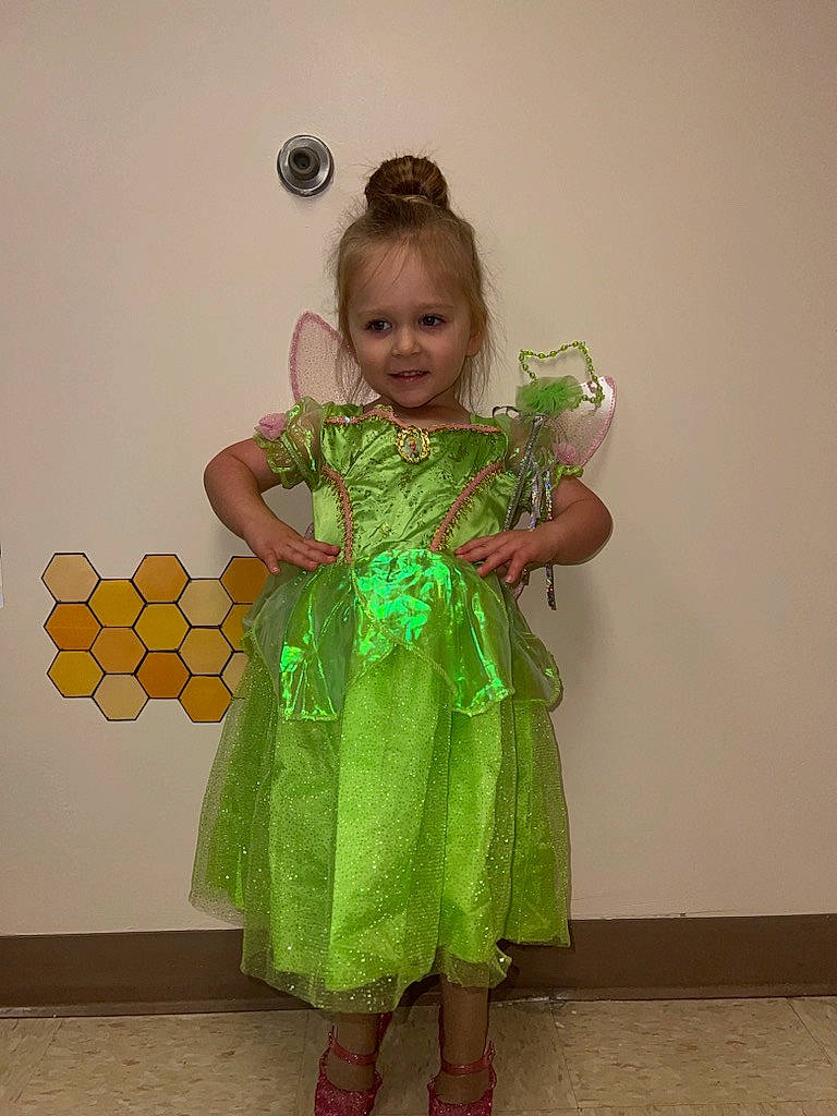 Parker is registered to the contest to win money with this photo: child, clothing, costume, day_dress, dress, entertainment, event, fashion_design, flooring, formal_wear, fun, happy, headpiece, joy, one_piece_garment, pattern, peach, performing_arts, person, shoulder