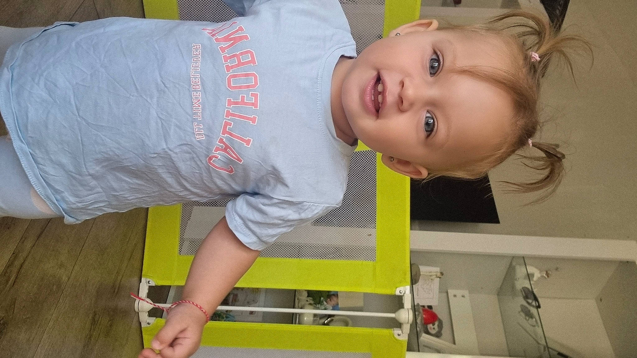 Aya is registered to the contest to win money with this photo: baby, baby_products, baby_toddler_clothing, cheek, child, elbow, eyelash, flooring, fun, happy, knee, mouth, pattern, person, room, sitting, sleeve, smile, t_shirt, toddler