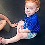 Henry is registered to the contest to win money with this photo: toddler, child, curly_hair, blue_shirt, patterned_shorts, trampoline, sitting, barefoot, outdoor, person, skin, legs, arm, expression, young_child, casual_clothing, playtime, summer, daylight, resting