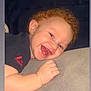 baby, child, smiling, red_hair, curly_hair, happy, face, skin, hand, blanket, soft_texture, lying_down, close_up, indoor, cute, infant, person, expression, cheerful, toddler