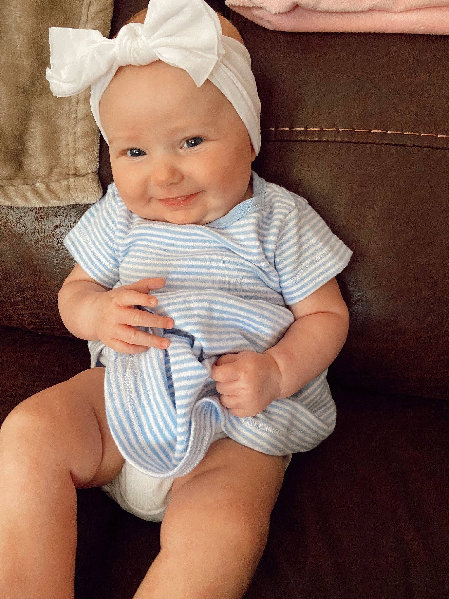 Sailor is registered to the contest to win money with this photo: arm, baby, baby_toddler_clothing, comfort, eye, face, finger, hand, happy, headgear, headwear, human_body, joy, knee, leg, neck, person, skin, sleeve, smile