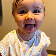 Rosalie a rejoint le concours — aidez-le/la à gagner de superbes lots ! baby, tongue, smiling, child, face, cute, portrait, happy, expression, clothing, floral_pattern, indoors, person, young_child, head, skin, eyes, mouth, cheeks, short_hair