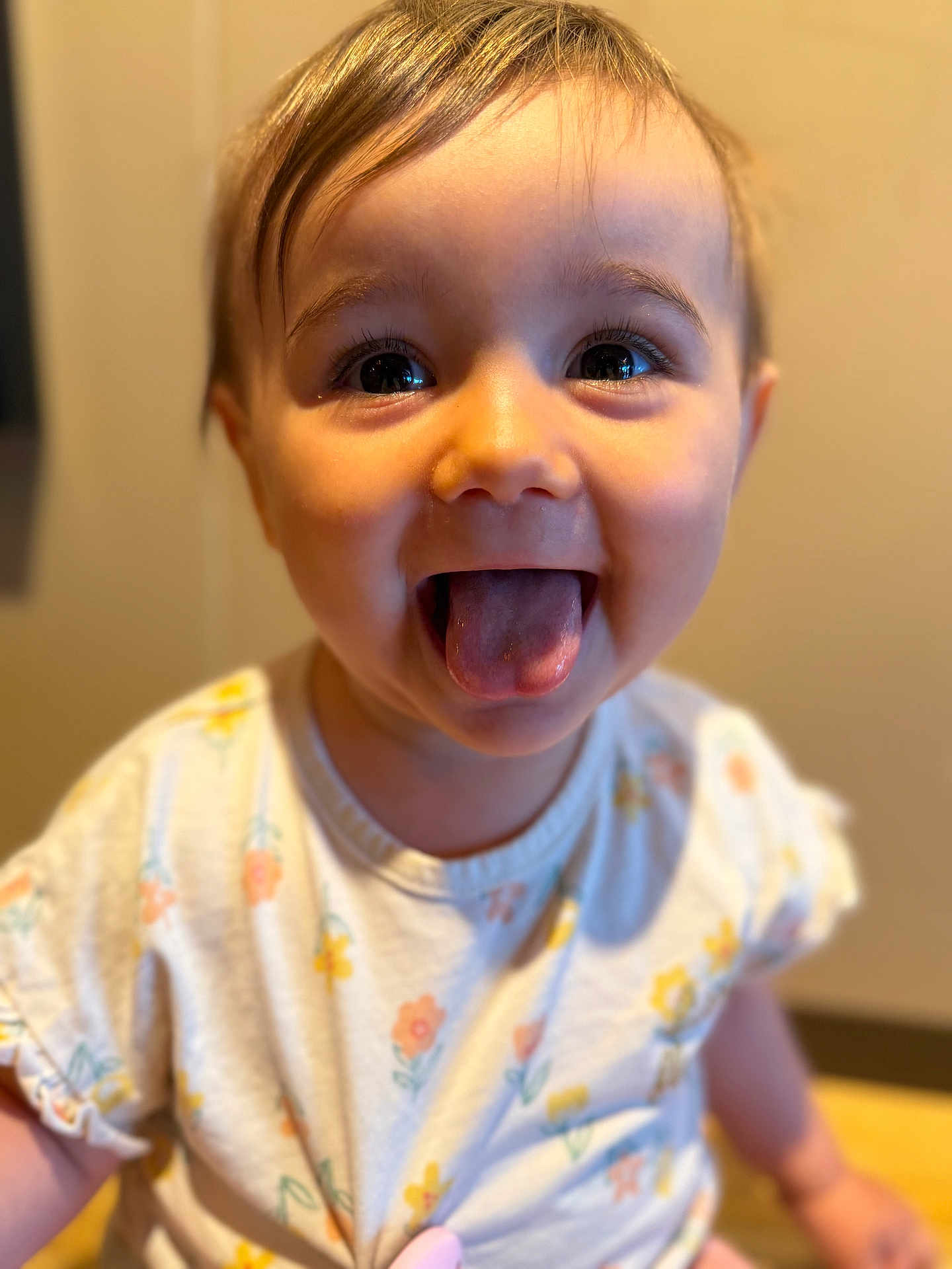 Rosalie a rejoint le concours — aidez-le/la à gagner de superbes lots ! baby, tongue, smiling, child, face, cute, portrait, happy, expression, clothing, floral_pattern, indoors, person, young_child, head, skin, eyes, mouth, cheeks, short_hair