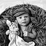 baby, infant, plush_toy, bunny, basket, blanket, fur_texture, black_and_white, portrait, hat, vest, cute, child, newborn, cozy, soft, hand, face, eyes, photography