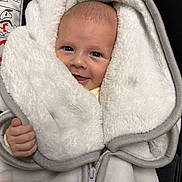 Nathan participe au concours pour gagner de l'argent avec cette photo : baby, smiling, face, blanket, white, soft, cozy, hand, infant, clothing, zipper, warm, cute, portrait, young_child, wrapped, indoor, happy, head, expression