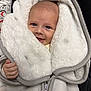 baby, smiling, face, blanket, white, soft, cozy, hand, infant, clothing, zipper, warm, cute, portrait, young_child, wrapped, indoor, happy, head, expression