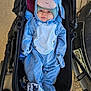 baby, bed, bonnet, cap, clothing, face, footwear, furniture, hat, head, hood, hoodie, knitwear, person, photography, portrait, shoe, stroller, sweater, sweatshirt