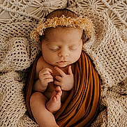 Juliette a rejoint le concours — aidez-le/la à gagner de superbes lots ! baby, newborn, infant, sleeping, swaddle, blanket, knit_blanket, textured_background, headband, flower_crown, toes, hands, closed_eyes, portrait, cozy, warm_tones, brown_wrap, beige, studio_photography, peaceful