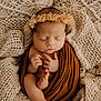 baby, newborn, infant, sleeping, swaddle, blanket, knit_blanket, textured_background, headband, flower_crown, toes, hands, closed_eyes, portrait, cozy, warm_tones, brown_wrap, beige, studio_photography, peaceful