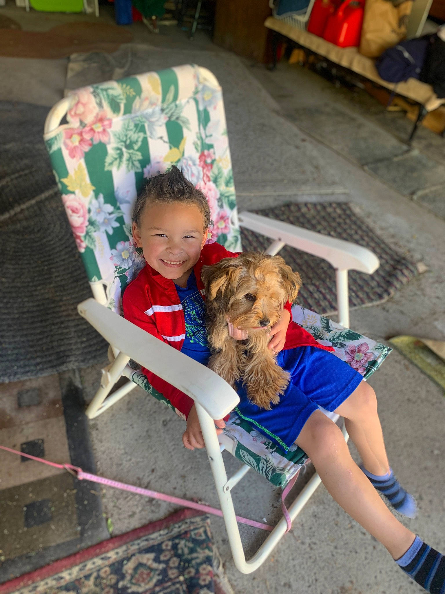 Justin is registered to the contest to win money with this photo: bench, carnivore, chair, child, companion_dog, dog, dog_breed, fun, furniture, human_leg, joy, lap, leisure, outdoor_furniture, person, recreation, shorts, sitting, smile, thigh