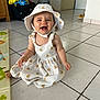 baby, child, smiling, happy, dress, hat, floor, tile, indoor, person, cute, sitting, childhood, playmat, home, young, infant, apparel, headwear, joy