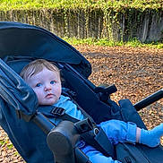 Emil a rejoint le concours — aidez-le/la à gagner de superbes lots ! baby, clothing, face, furniture, grass, gun, head, land, nature, outdoors, pants, park, person, photography, plant, portrait, stroller, tree, vegetation, weapon