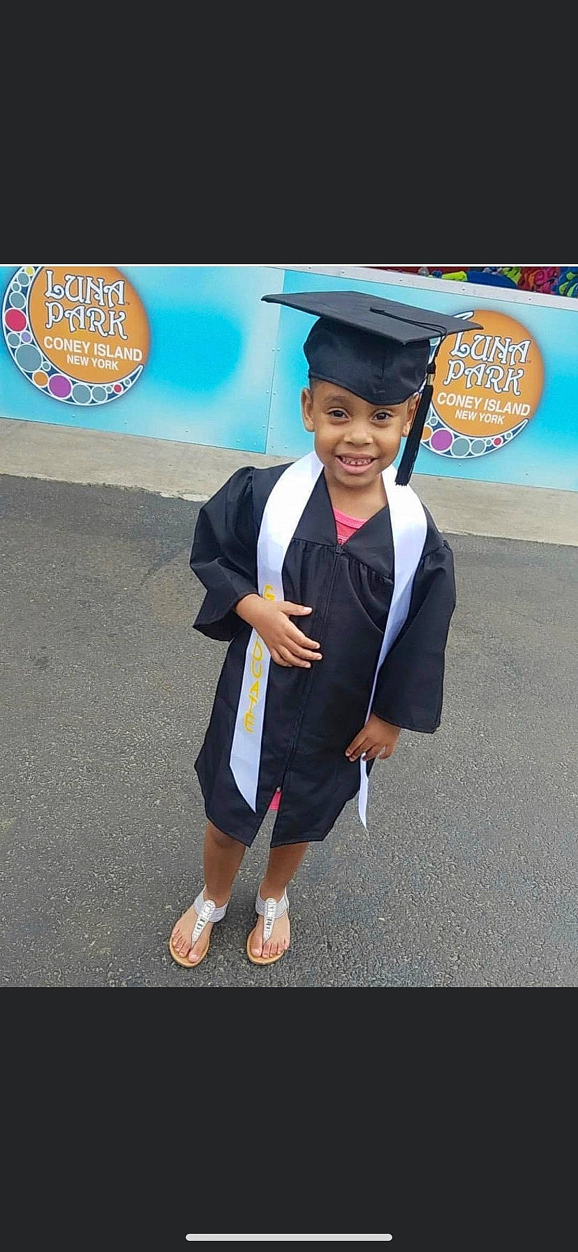 Faith is registered to the contest to win money with this photo: academic_dress, academic_institution, child, electric_blue, event, fashion_accessory, fun, gesture, graduation, happy, headgear, headwear, joy, logo, mortarboard, person, phd, public_event, scholar, smile