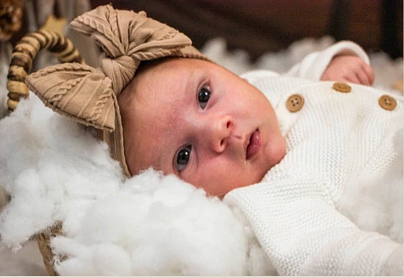 Talia participe au concours pour gagner de l'argent avec cette photo : baby, baby_products, baby_toddler_clothing, cheek, child, close_up, comfort, eyelash, flash_photography, fur, happy, hat, headgear, headwear, linens, lip, person, portrait_photography, room, skin