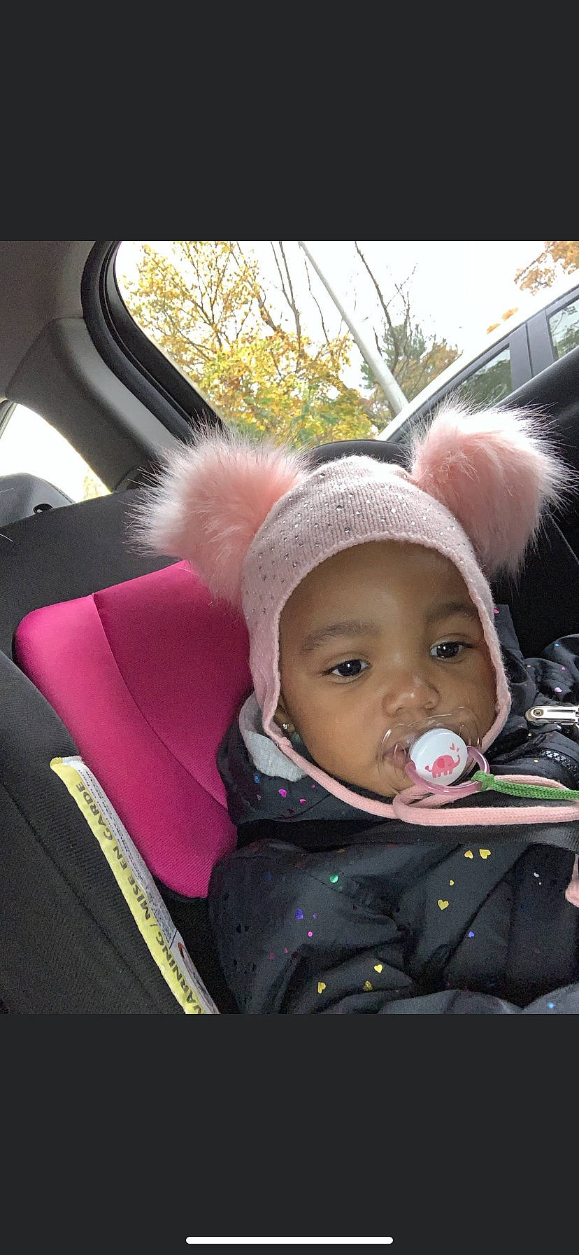 Eryn is registered to the contest to win money with this photo: car_seat, child, family_car, fur, joy, person, pink, steering_wheel, toddler