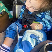 Neptune is registered to the contest to win money with this photo: toddler, child, sleeping, car_seat, blue_clothing, sock, bandage, hand, seatbelt, safety, car_interior, peaceful, nap, young_child, cute, patterned_clothes, baby, resting, seat, closeup