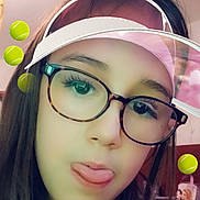 Jena participe au concours pour gagner de l'argent avec cette photo : casual_clothing, child, digital_filter, face, fun, girl, glasses, headshot, indoors, long_hair, person, playful, portrait, selfie, smiling, tennis_balls, tongue_out, virtual_effects, visor_hat, young