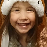 Malya participe au concours pour gagner de l'argent avec cette photo : child, smile, hat, animal_hat, fluffy, brown, white, face, happy, indoors, clothing, cute, portrait, young, person, long_hair, warm, fun, joy, headwear