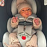 baby, car_seat, knit_hat, knit_booties, knit_sweater, infant, child, seat_belt, car_interior, cute, warm_clothing, pom_pom, newborn, portrait, sitting, childrens_fashion, safety, indoors, person, young_child