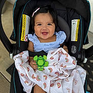Fernanda is registered to the contest to win money with this photo: baby, baby_girl, blanket, car_seat, child, closeup, clothing, colorful, cute, hair_clip, happy, indoors, infant, patterned_blanket, person, portrait, seatbelt, smiling, toy, turtle