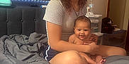 Kristiahnna joined the competition — help win amazing prizes! baby, bed, blanket, child, curly_hair, foot, furniture, hand, indoor, mirror, person, room, shorts, sitting, skin, smiling, tshirt, wall_art, water_bottle, young_girl