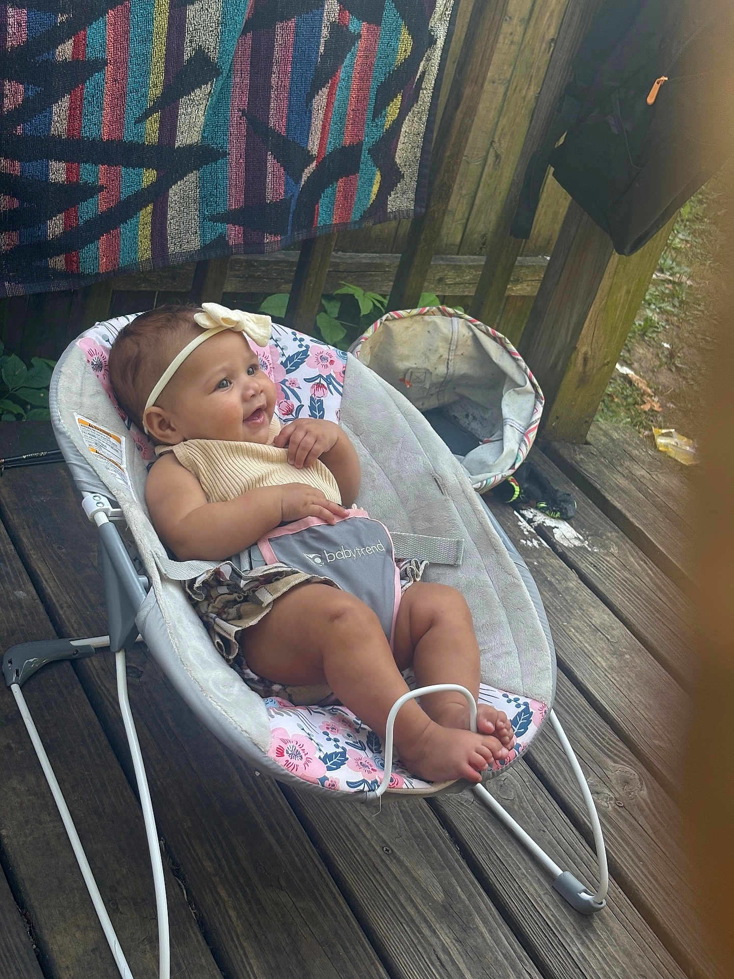 Kristiahnna joined the competition — help win amazing prizes! baby, infant, bouncer, headband, wooden_deck, blanket, outdoor, child, smile, happy, clothing, footwear, baby_seat, person, skin, toy, flower_pattern, fabric, relaxing, cute