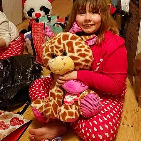 Georgia is registered to the contest to win money with this photo: beauty, child, event, fawn, giraffe, giraffidae, happy, head, joy, pattern, person, pink, plush, product, room, smile, snapshot, stuffed_toy, teddy_bear, textile