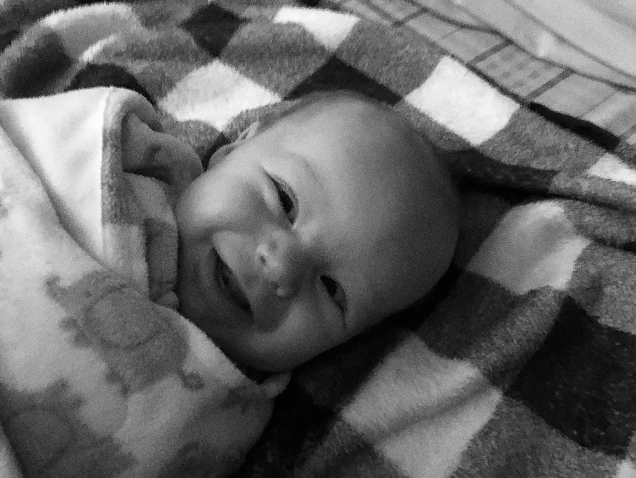 Kenai is registered to the contest to win money with this photo: baby, baby_toddler_clothing, bedding, bedtime, child, comfort, grass, happy, linens, monochrome, monochrome_photography, pattern, person, portrait_photography, room, skin, sleep, sleeve, smile, tints_and_shades