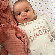 Mya joined the competition — help win amazing prizes! baby, infant, child, blanket, pink, clothing, cute, smile, face, portrait, soft, bed, text_on_clothing, floral, collar, lying_down, young, adorable, expression, warm