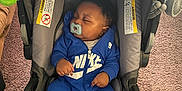 Haissam joined the competition — help win amazing prizes! baby, infant, sleeping, pacifier, car_seat, blue_clothing, socks, toy, indoor, carpet, child, person, couch, blanket, comfort, rest, hood, infant_clothing, cozy, relaxation