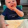 baby, child, high_chair, messy, food, smiling, face, hand, blue_shirt, indoor, happy, young_child, person, cute, table, eating, infant, small_child, mess, portrait