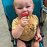 Nelson is registered to the contest to win money with this photo: baby, barefoot, casual_clothing, chewing, child, curious, cute, daylight, outdoor, person, play, red_hair, sidewalk, sitting, stroller, summer, toddler, toy, yellow_shirt, young_child