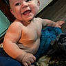 baby, smile, happy, child, indoor, floor, blanket, blue, skin, shorts, person, cute, chubby, infant, sitting, expression, joyful, home, young, playful