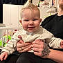 Harper-Kay joined the competition — help win amazing prizes! adult_hand, baby, black_pants, child, crib, cute, furniture, hand, happy, holding, home, human, indoor, mohawk_hairstyle, person, portrait, room, smiling, sweater, tattoo