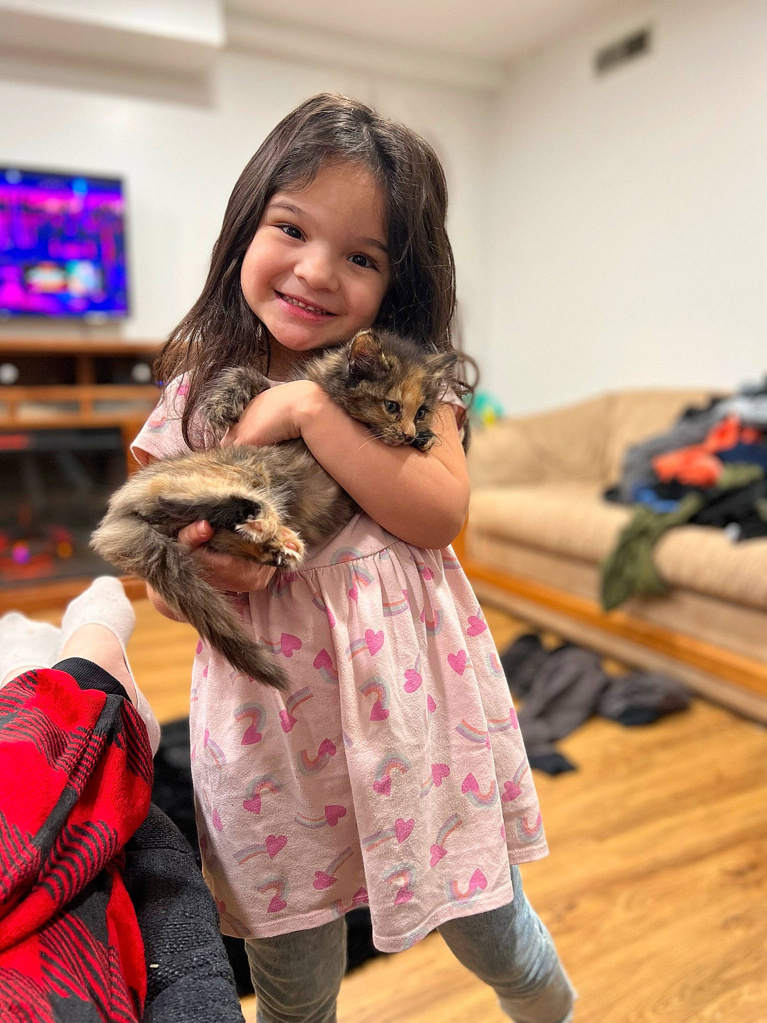 Raina is registered to the contest to win money with this photo: child, dress, event, fashion_design, fawn, felidae, flooring, fun, fur, gesture, happy, joy, long_hair, mammal, pattern, person, skin, sleeve, smile, textile