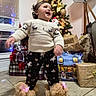 toddler, child, christmas_tree, pajamas, slippers, holiday, presents, decorations, indoor, smiling, happy, floor, lamp, window, curtains, home, celebration, festive, toy, cozy