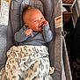 Demetrius is registered to the contest to win money with this photo: baby, infant, smiling, blanket, cactus_pattern, baby_bouncer, gray, cozy, indoors, face, happy, hand, clothing, woven_basket, home, comfort, portrait, cute, child, resting
