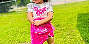 Londynn is registered to the contest to win money with this photo: child, girl, birthday_crown, pink_skirt, white_shirt, sandals, grass, outdoor, daylight, curly_hair, pouty_expression, summer, greenery, fence, background, standing, person, nature, sunny, casual_clothing